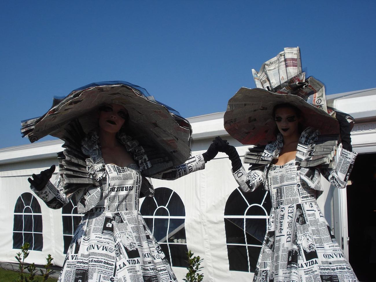 Steltlopers in krantenkostuums
