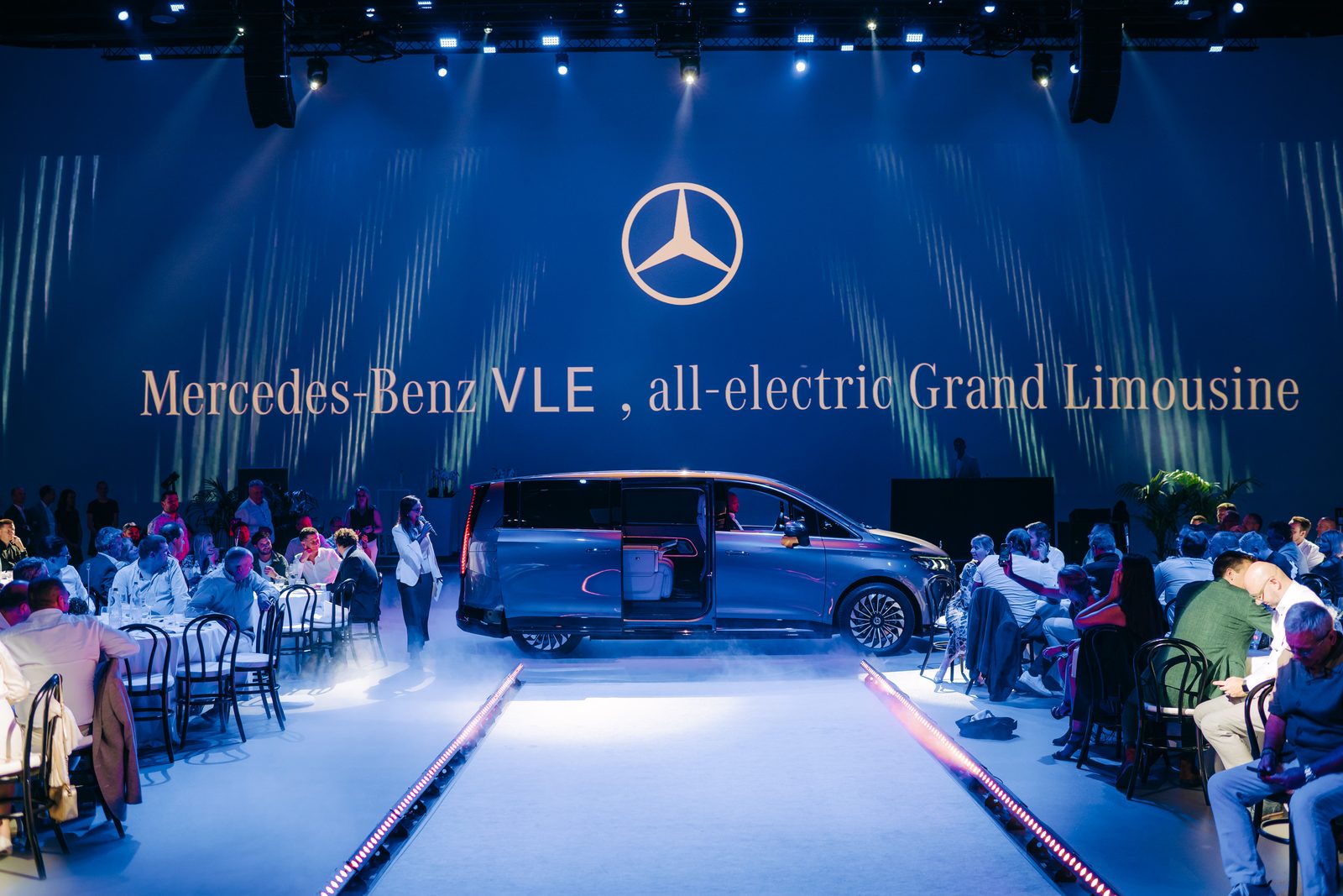 Lancering van de elektrische Mercedes-Benz VLE op een podium met tafels errond